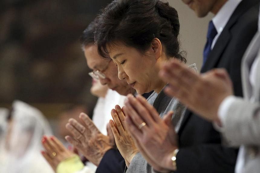 South Korean President Park Geun Hye (centre) prays during a Mass in memory of victims of the sunken Sewol ferry at a Catholic church in Seoul on May 18, 2014. Amid nationwide anger over the incident, Ms Park met relatives of the victims on Friday, r