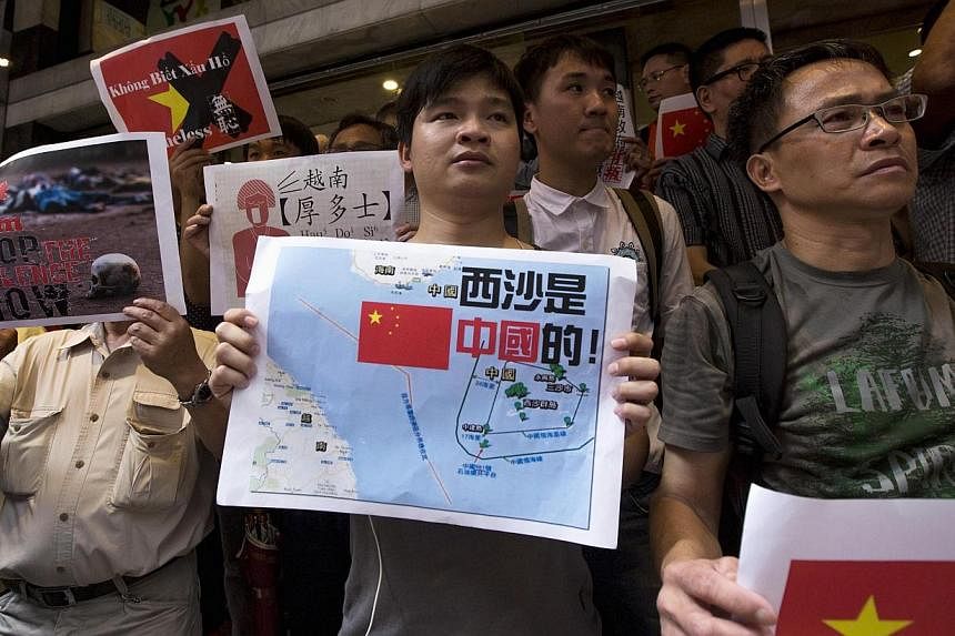 Anti-Vietnam protesters hold posters with slogans and a picture showing a map of the South China Sea including the Paracel Islands, during a protest defending China's territory claim and condemning Vietnam's anti-Chinese protests, in Hong Kong May 19