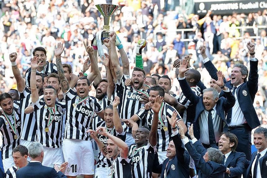 Juventus' coach Antonio Conte, players and staff celebrate the "scudetto" (Italian championship trophy) at the end of the Italian Serie A football match Juventus FC vs Cagliari Calcio at the Juventus Stadium in Turin, Italy, on May 18 2014. -- PHOTO: