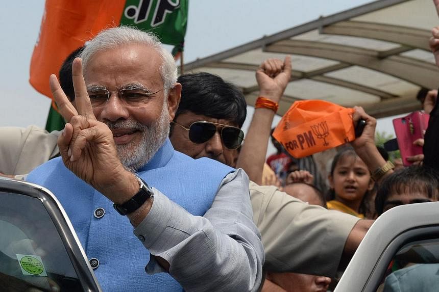 Mr Narendra Modi (in blue) waves as he arrives at Indira Gandhi International Airport in New Delhi on May 17, 2014. -- FILE PHOTO: AFP
