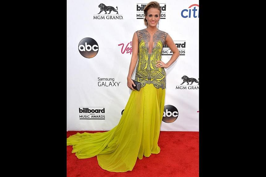 Carrie Underwood pops in her bright yellow Oriett Domenech gown with sequinned embellishments.&nbsp;&nbsp;-- PHOTO: AFP