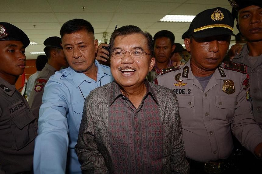 Former Indonesian vice president Jusuf Kalla (centre) leaves the Indonesia's Corruption Court in Jakarta on May 8, 2014. -- FILE PHOTO: AFP