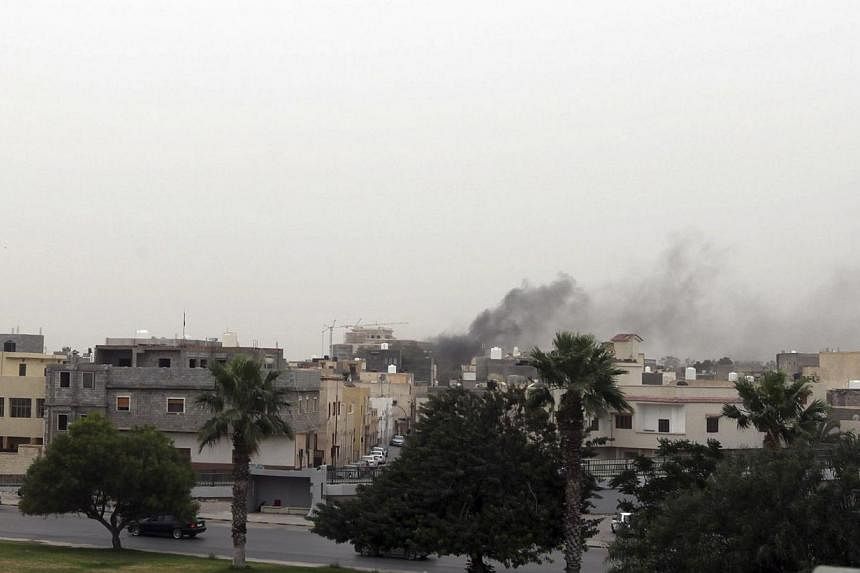 Smoke rises over the General National Congress building in Tripoli on May 18, 2014. -- PHOTO: REUTERS
