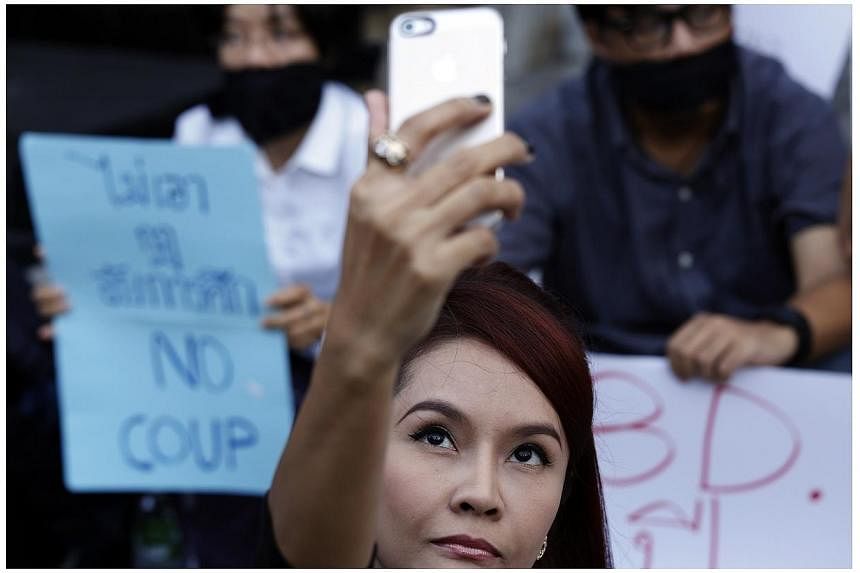 A woman takes a "selfie" photograph as activists attend a small protest against the declaration of martial law and the army's involvement in politics, in central Bangkok, on May 20, 2014. -- PHOTO: REUTERS&nbsp;