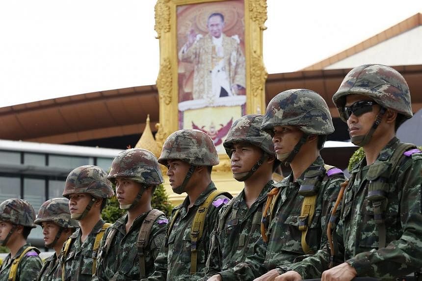 Thai soldiers next to portrait of King Bhumibol Adulyadej after the declaration of martial law at the Army Club in Bangkok, Thailand, 20 May 2014.&nbsp;Thailand's army chief said rival political groups should talk to each other and that the martial l
