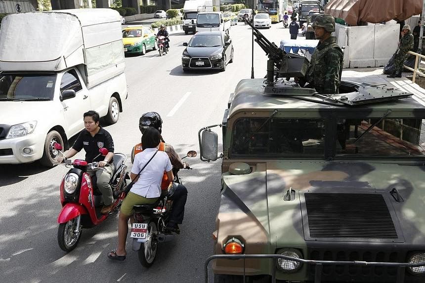 Motorists on their way as Thai soldiers take to the streets with a heavy machine gun on a Humvee military vehicle at a main road outside the Royal Thai Police Sports Club in Bangkok, Thailand on May 20, 2014.&nbsp;The Philippines on Tuesday, May 20, 
