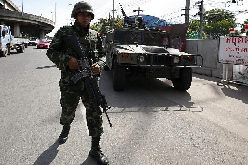 Thai soldiers on patrol after the declaration of martial law at a main road outside the Royal Thai Police Sports Club in Bangkok, Thailand on May 20, 2014.&nbsp;Thai mainstream media on Tuesday, May 20, 2014, greeted the imposition of martial law and