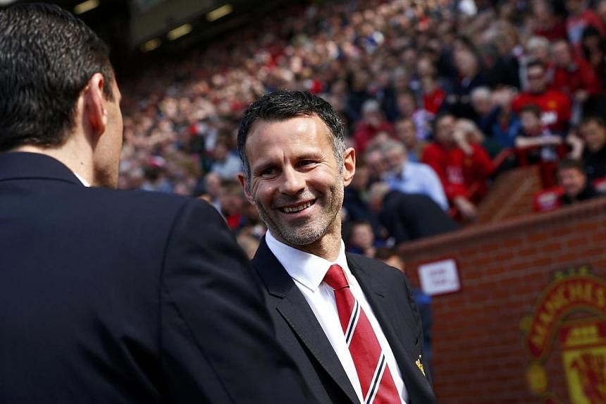 Manchester United caretaker player manager Ryan Giggs (right) greets Sunderland manager Gus Poyet before their English Premier League football match at Old Trafford in Manchester, May 3, 2014. -- FILE PHOTO: REUTERS