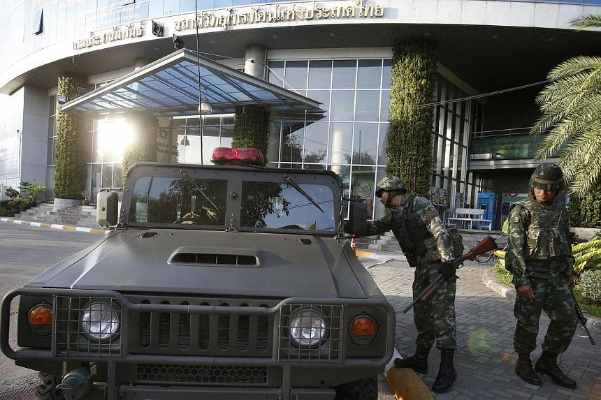 Thai soldiers stand in front of the National Broadcasting Services of Thailand television station in Bangkok on May 20, 2014. -- PHOTO: REUTERS