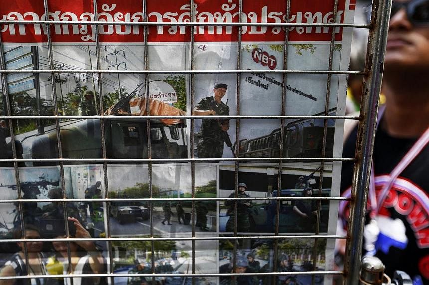 An anti-government protester reads morning papers displayed inside the encampment in central Bangkok on May 21, 2014. The next phase in the Thailand's long-winding political crisis depends, at least partly, on a series of meetings that are to take pl