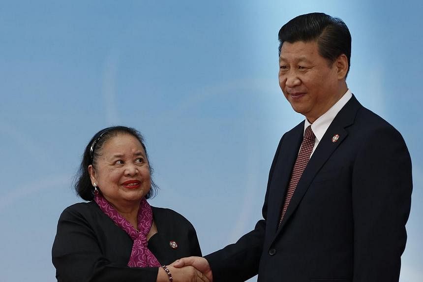 Philippines Ambassador to china Erlinda Basilio (left) and Chinese President Xi Jinping shake hands before the opening ceremony at the Expo Center at a summit in Shanghai on May 21, 2014. Mr Xi issued a veiled warning to the United States on Wednesda
