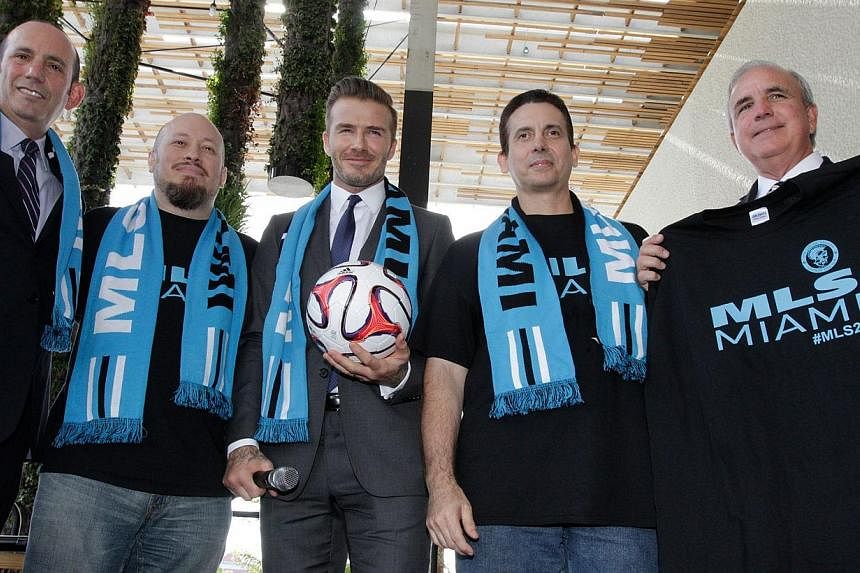 A file picture taken on Feb 5, 2014 shows former England and Manchester United star, David Beckham (centre) posing for photos Major League Soccer Commissioner Don Garber (left) and Miami-Dade County Mayor Carlos Gimenez (right) after holding a press 