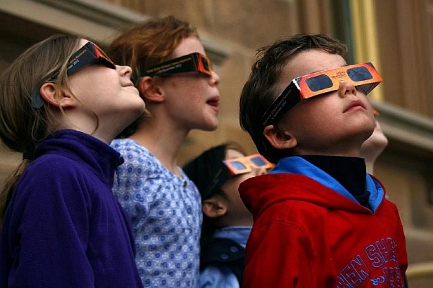 Children wear protective glasses as they try to see a partial solar eclipse from Sydney's Observatory Hill on April 29, 2014.&nbsp;Australian children are among the least active in the world, ranking behind those in Britain and New Zealand, researche