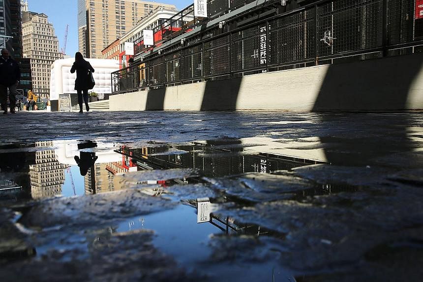 People walk through South Street Seaport, an area of lower Manhattan that was severely flooded during Hurricane Sandy on March 31, 2014 in New York City.&nbsp;Climate change and sea level rise are threatening historic US landmarks, from the Statue of