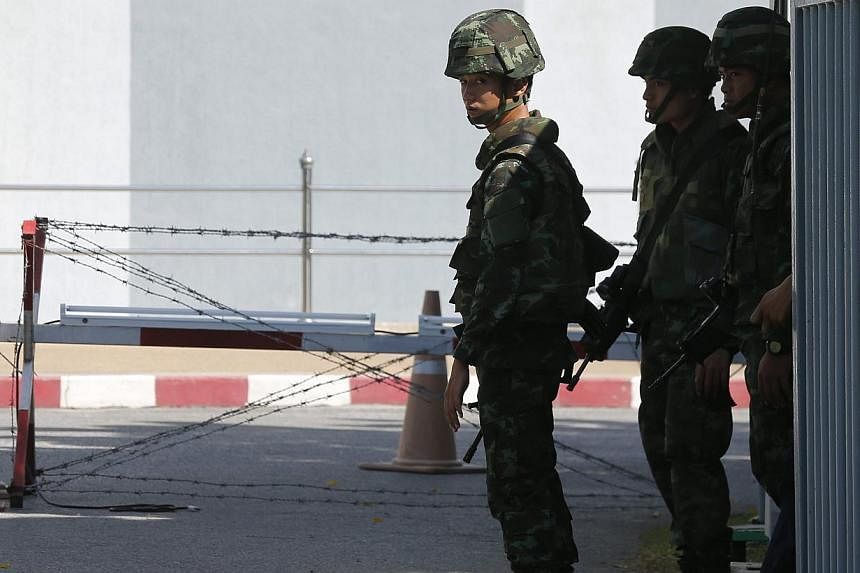 Thai armed soldiers stand guard at the gate of Voice TV satellite tv station office in Bangkok, Thailand, on May 21, 2014. -- PHOTO: EPA