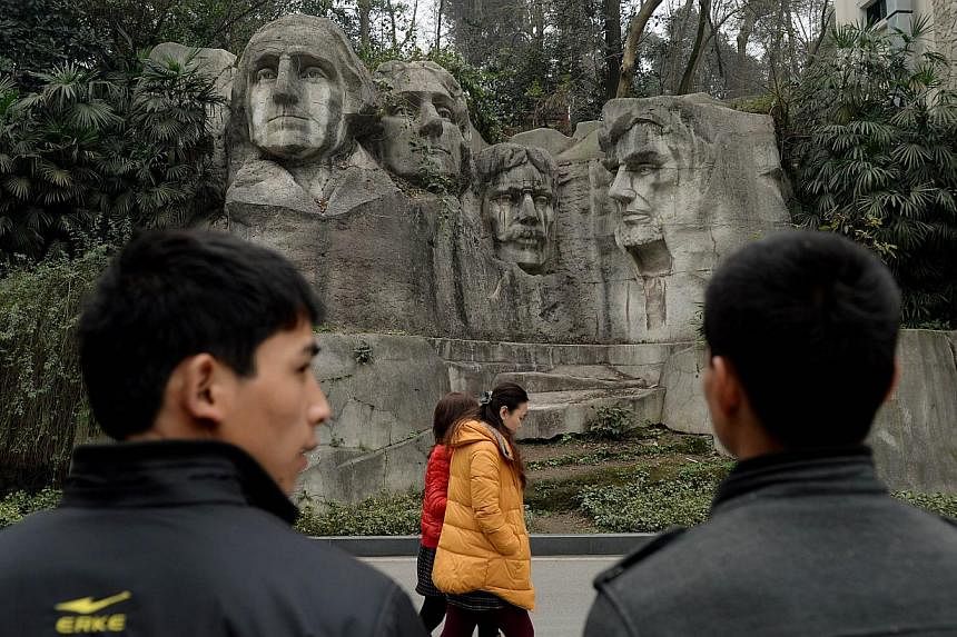 This photo taken on on February 21, 2014 shows people walking past a copy of Mount Rushmore at a park in Chongqing. Already renowned for copying Western goods from trainers to champagne, China is building up its replica reputation with a miniature Mo