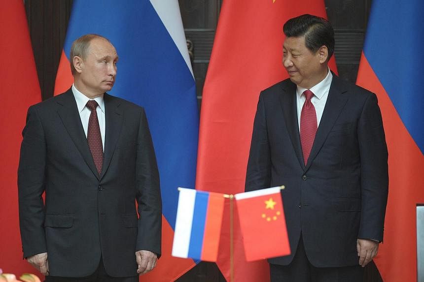 Russian President Vladimir Putin (L) and President Xi Jinping (R) of China attend the ceremony of signing of joint documents after Russian-Chinese talks at the Xijiao state residence in Shanghai, China on 20 May 2014. The two leaders on May 21, 2014&
