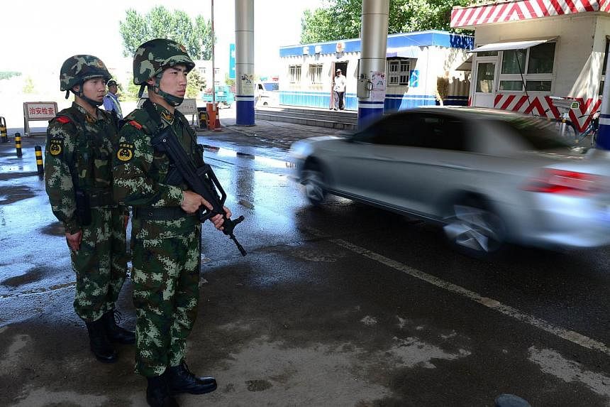 Chinese security personnel guarding a checkpoint along one of the highways leading into Beijing on May 20, 2014. -- PHOTO: AFP
