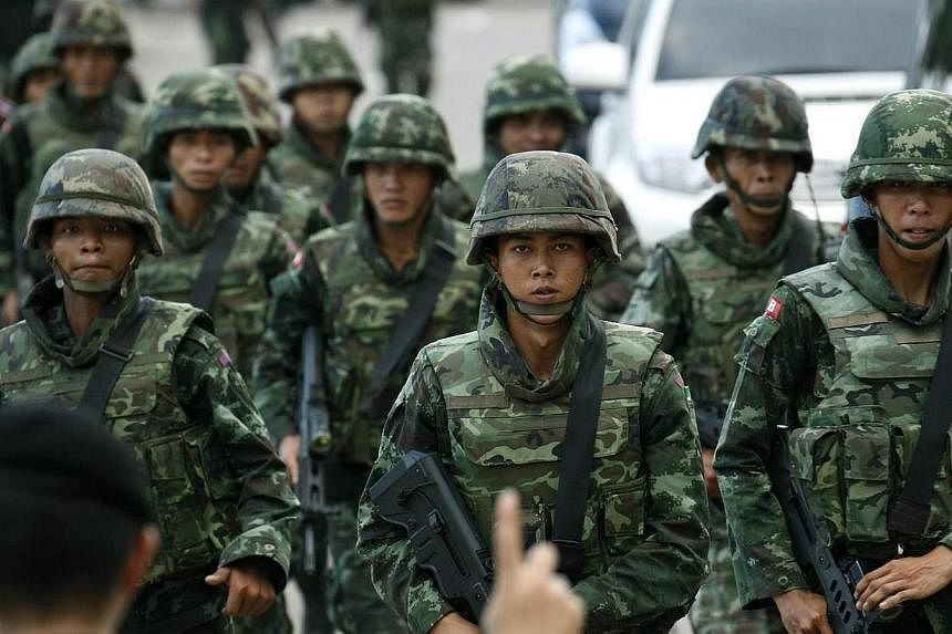 Thai armed soldiers stand guard position after a meeting between the army and the main political rivals on second day at the Army Club, in Bangkok, Thailand on Thursday, May 22, 2014. Thailand’s military on Thursday ordered all television and radio