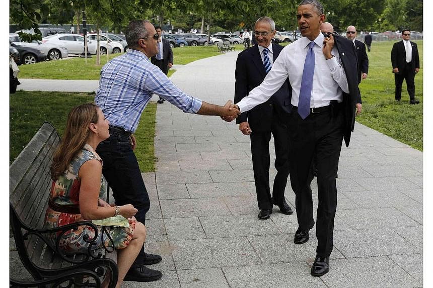 US President Barack Obama shakes hands with Israeli tourists while walking on the Ellipse with White House counselor John Podesta near the White House in Washington on May 21, 2014. -- PHOTO: REUTERS