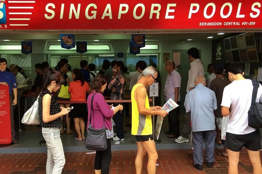 People queue at a Singapore Pools outlet at Serangoon Central Drive on Friday, May 23, 2014.&nbsp;Four people are holding the winning tickets for Friday's Toto $5 million anniversary draw. -- ST PHOTO: KEVIN LIM