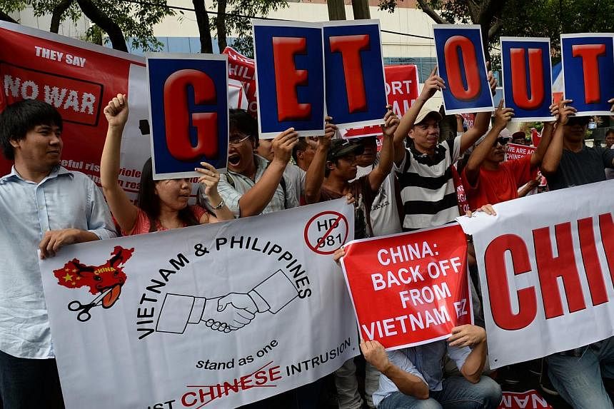 Vietnamese and Philippine protesters shout anti-China slogans and hold placards during a rally in front of the Chinese consular office in the financial district of Manila on May 16, 2014. -- PHOTO: AFP