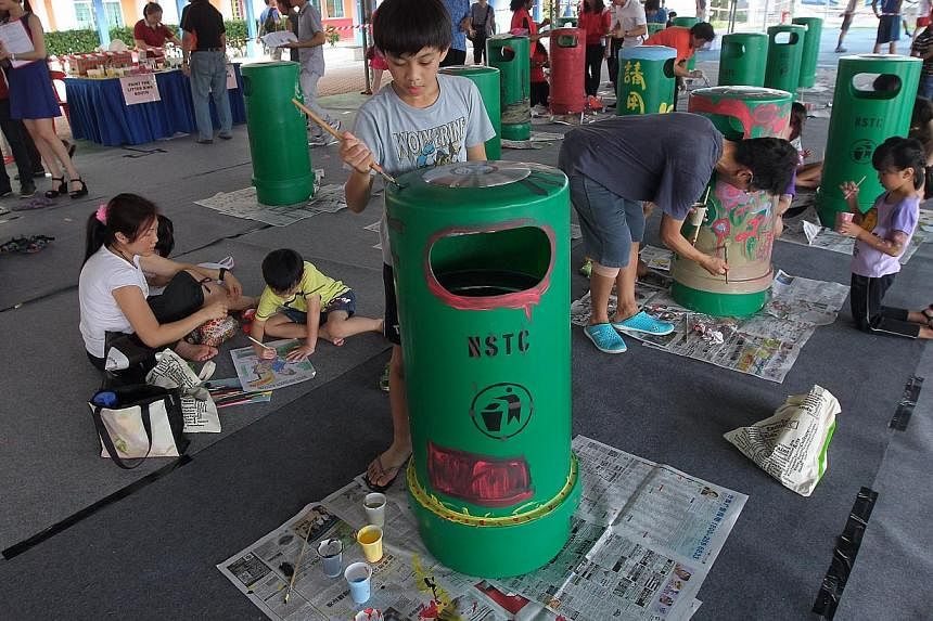 Residents, grassroots leaders and school students, together with Nee Soon GRC MP Lee Bee Wah, came together to paint lift doors and litter bins to spread the message of giving way to the elderly and not littering. -- ST PHOTO: NEO XIAOBIN