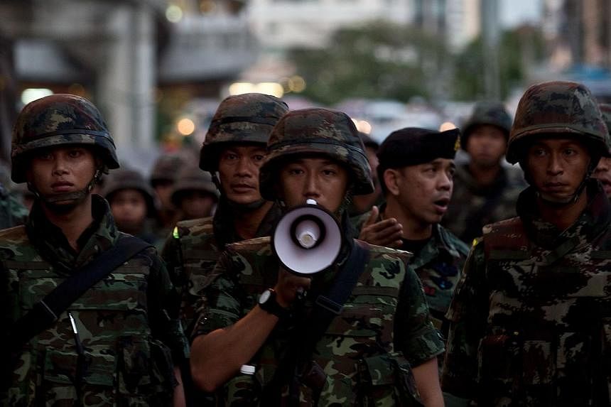 Thai army soldiers urge anti-coup protestors to maintain law and order during a protest in downtown Bangkok on May 23, 2014. -- PHOTO: AFP