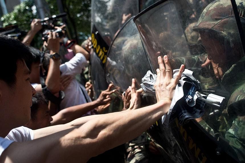 Anti-coup protesters scuffle with Thai soldiers ahead of a planned gathering in Bangkok on May 24, 2014. - PHOTO: AFP