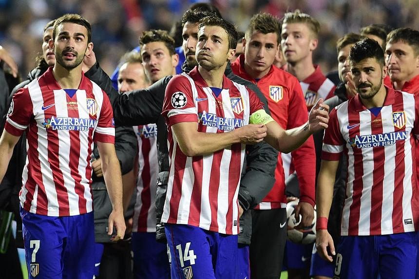 (From left) Atletico Madrid's forward Adrian Lopez, Atletico Madrid's midfielder and captain Gabi and Atletico Madrid's forward David Villa react at the end of the Uefa Champions League Final Real Madrid vs Atletico de Madrid at Luz stadium in Lisbon