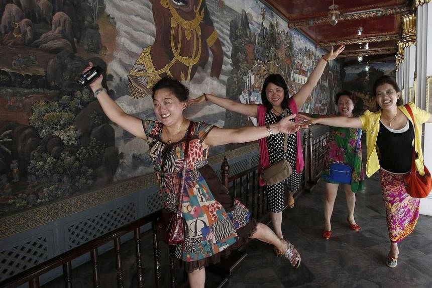Chinese tourists pose for a picture inside the Grand Palace in Bangkok on May 24, 2014. -- PHOTO: REUTERS