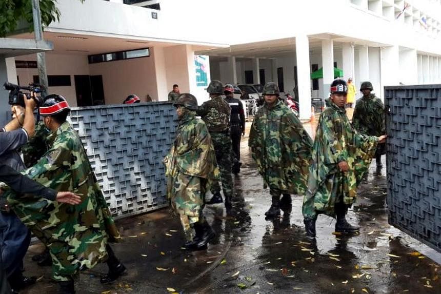 Soldiers closing the gates of the army office on Sunday morning after prominent Thai journalist Pravit Rojanaphruk walked in to report to the junta.Mr Pravit is the first journalist to be summoned by the junta since it seized power on Thursday. -- ST