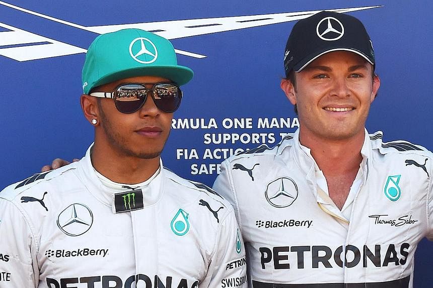 Mercedes' British driver Lewis Hamilton (left) and Mercedes' German driver Nico Rosberg pose in the parc ferme of the Monaco street circuit after the qualifying session of the Monaco Formula One Grand Prix in Monte Carlo on May 24, 2014. -- PHOTO: AF