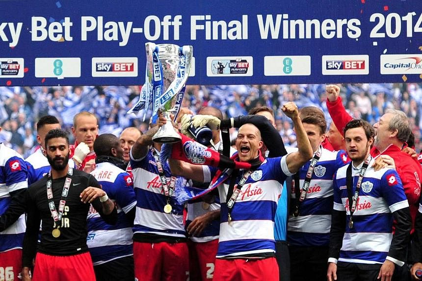 Queens Park Rangers (QPR) players celebrate with the trophy after winning the English Championship Play Off final football match against Derby County at Wembley Stadium in London on May 24, 2014. -- PHOTO: AFP
