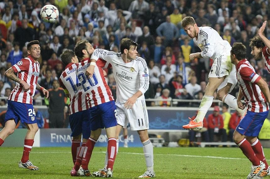 Real Madrid's defender Sergio Ramos (third, right) scores during the UEFA Champions League Final Real Madrid vs Atletico de Madrid at Luz stadium in Lisbon, on May 24, 2014.&nbsp;- PHOTO: AFP