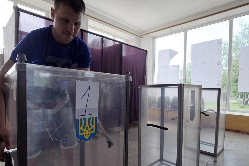 A member of the election commission prepares voting boxes at a polling station in a small village bordering the Kharkiv and Donetsk regions on May 24, 2014, a day before early presidential election in the country. - PHOTO: AFP