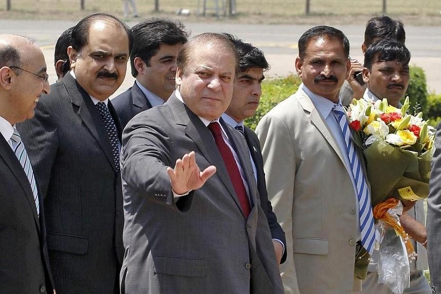 Pakistan's Prime Minister Nawaz Sharif waves upon his arrival at the airport in New Delhi on May 26, 2014.&nbsp;Pakistan Prime Minister Nawaz Sharif arrived in New Delhi on Monday, May 26, 2014, for the swearing-in ceremony of his incoming Indian cou
