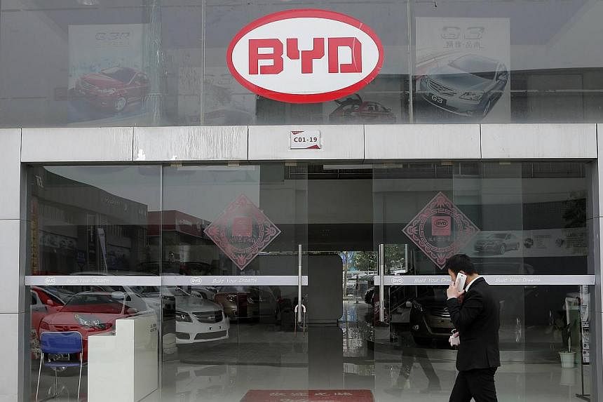 A man walks past a BYD store in Wuhan, Hubei province, March 20, 2014. Shares of Chinese carmaker BYD Co fell 5 per cent in Hong Kong after the company launched a new share issue seeking to raise up to US$551 million (S$690 million). -- FILE PHOTO: R