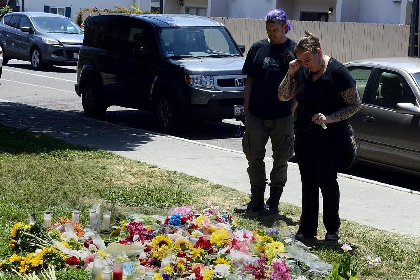 A woman cries as she looks at a make-shift memorial set up outside the Alpha Phi sorority where two women died during the deadly shooting rampage at the college town of Isla Vista, California, USA, May 25, 2014. -- PHOTO: EPA
