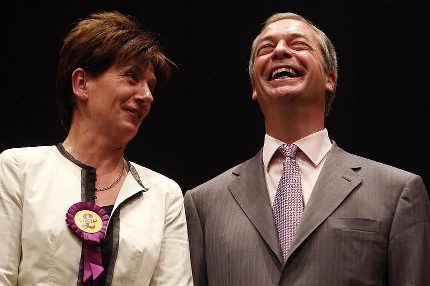 UK Independence Party (UKIP) leader Nigel Farage and UKIP candidate Diane Jones (left) smile after the declaration of results of the European Parliament election for the south east region, in Southampton, southern England May 25, 2014. -- PHOTO: REUT