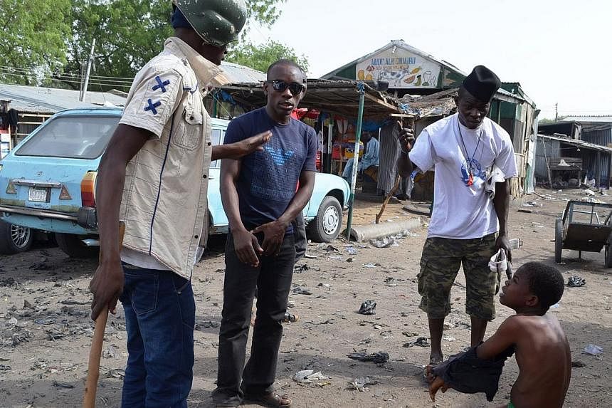 Vigilantes dubbed 'Civilian JTF' interrogate a suspected Boko Haram informant in Jajeri neighbourhood of the north-east Nigerian city of Maiduguri on May 24, 2014. -- PHOTO: AFP