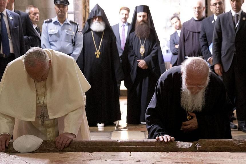 Pope Francis and Constantinople Patriarch Bartholomew kneel to kiss the Stone of Unction, traditionally claimed as the stone where Jesus' body was prepared for burial, in the Church of the Holy Sepulchre, in Jerusalem, Israel, May 25, 2014. -- PHOTO: