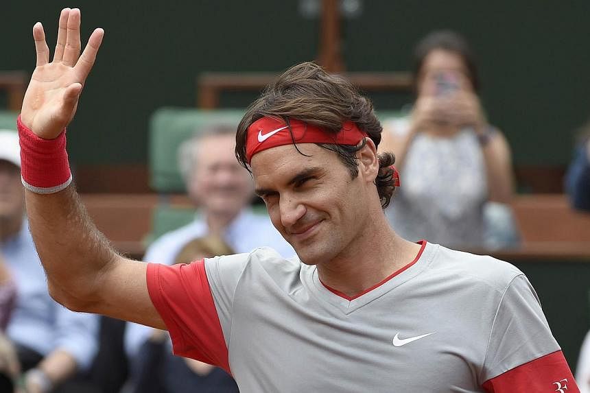 Switzerland's Roger Federer waves at the crowd after winning his French tennis Open first round match at the Roland Garros stadium in Paris on May 25, 2014. -- PHOTO: AFP&nbsp;
