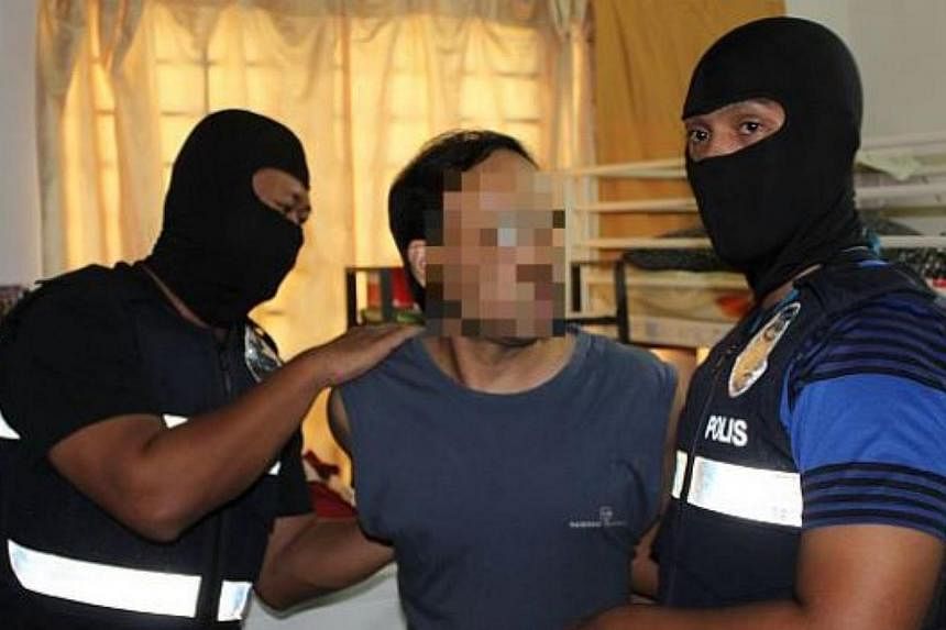 One of the three Sri Lankan men being detained by police officers in Bandar Utama. -- PHOTO: THE STAR/ASIA NEWS NETWORK&nbsp;