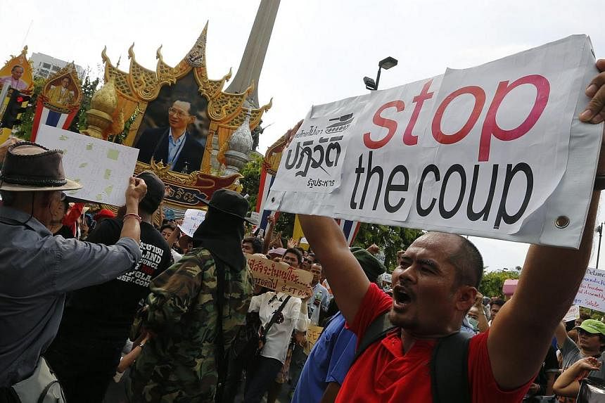 A Thai anti-coup protester holds a placard and shout slogans during a protest against coup at Victory Monument in Bangkok, Thailand, May 25, 2014. -- PHOTO: EPA