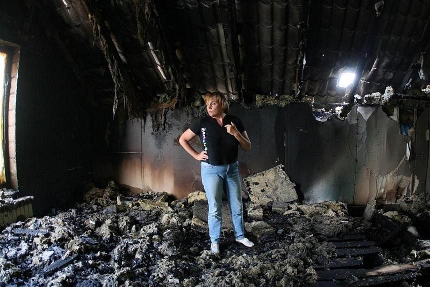 A woman looks at her building destroyed as a result of Monday's combat of Ukrainian troops with pro-Russia separatists near the International airport in Donetsk on May 27, 2014.&nbsp;Ukrainian forces fought with separatists in the city of Donetsk for