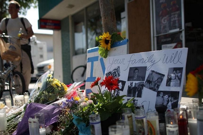 Photos of a victim stand in a makeshift memorial in front of the IV Deli on May 25, 2014 in Isla Vista, California.&nbsp;Penang-born Ong Li Chin raced against time in a desperate bid to save her son Elliot Rodger from making a fatal mistake. -- PHOTO