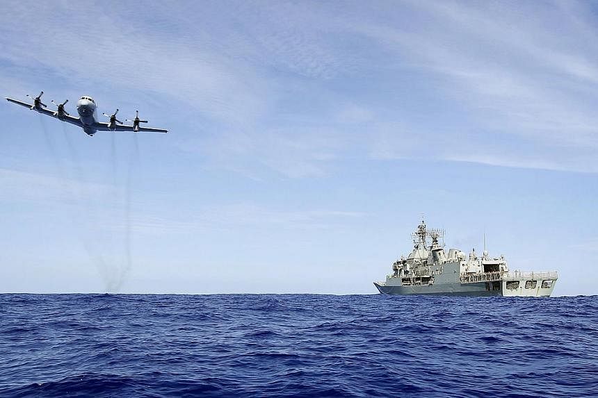 A photo taken on April 7, 2014 and released by Australian Defence on April 11 shows a Royal Australian Air Force AP-3C Orion from 92 Wing, conducting a low level fly by before dropping stores to HMAS Toowoomba during the search for the missing Malays