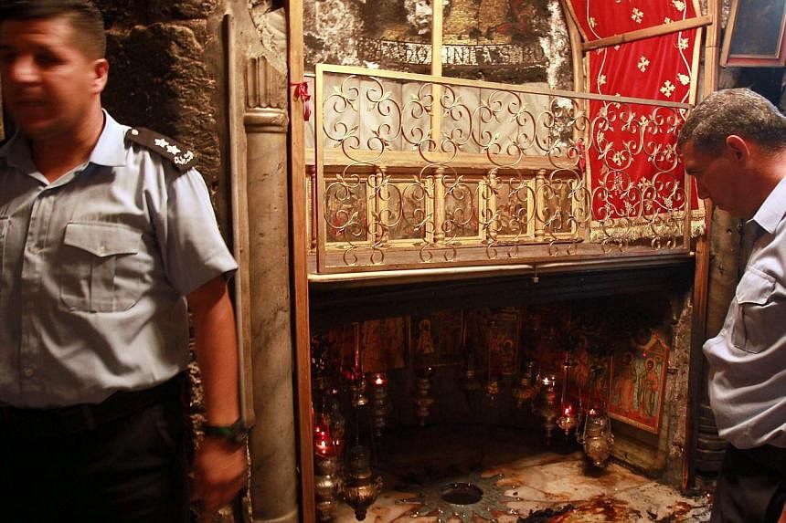 Palestinian police inspect the Grotto, at the Church of the Nativity, believed to be the birthplace of Jesus Christ, on May 27, 2014. A fire broke out just hours after Pope Francis wrapped up a three-day Middle East pilgrimage which saw him visit the