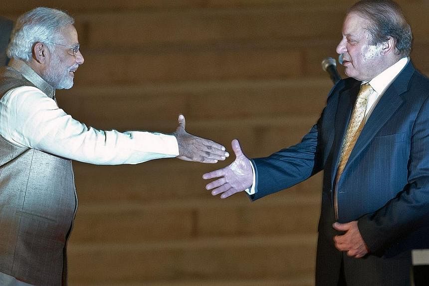 Newly sworn-in Indian Prime Minister Narendra Modi (left) prepares to shake hands with Pakistani Prime Minister Nawaz Sharif after the swearing-in ceremony at the Presidential Palace in New Delhi on May 26, 2014. -- PHOTO: AFP